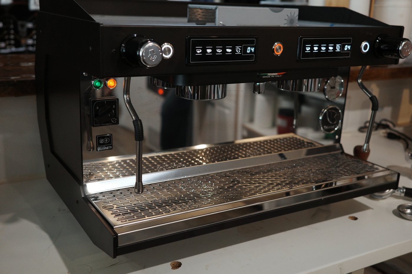 A two-group espresso machine installed and running on a cafe bar